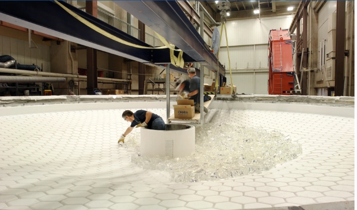 Technicians loading chunks of glass onto the honeycomb casting mold